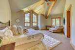 Experience rustic charm in this inviting bedroom, featuring a cozy bed adorned with plush pillows and a textured quilt.