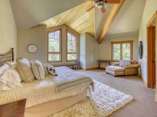 Experience rustic charm in this inviting bedroom, featuring a cozy bed adorned with plush pillows and a textured quilt.