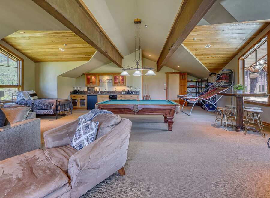 This spacious recreational room offers a perfect blend of relaxation and entertainment, featuring a full-size pool table and a well-equipped wet bar.
