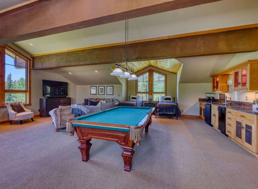 This spacious recreation room offers a perfect blend of entertainment and relaxation, featuring a full-size pool table as the centerpiece.