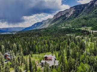 Nestled amidst a lush forest and towering mountains, this stunning property offers a serene escape with breathtaking natural beauty.