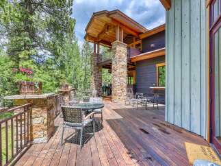 Enjoy outdoor living on this expansive wooden deck, perfect for entertaining or relaxing amidst lush greenery.