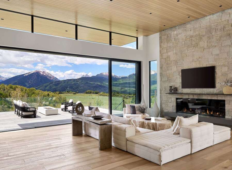 Experience luxurious mountain living in this stunning contemporary home, featuring expansive glass walls that seamlessly blend indoor and outdoor spaces with breathtaking panoramic views.