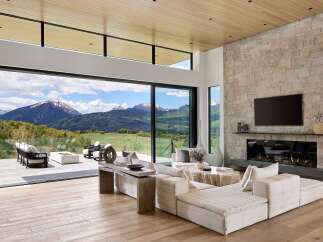 Experience luxurious mountain living in this stunning contemporary home, featuring expansive glass walls that seamlessly blend indoor and outdoor spaces with breathtaking panoramic views.