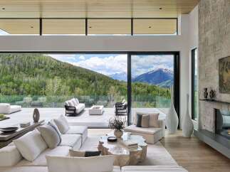 Experience luxurious mountain living in this stunning home, featuring expansive glass walls that seamlessly blend indoor and outdoor spaces.