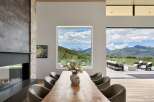 Experience luxurious mountain living in this stunning dining room, featuring a live-edge wood table and plush upholstered chairs.