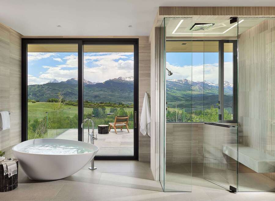 Experience ultimate relaxation in this luxurious bathroom featuring a freestanding soaking tub with stunning mountain views.