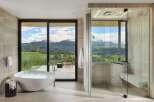 Experience ultimate relaxation in this luxurious bathroom featuring a freestanding soaking tub with stunning mountain views.