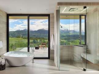Experience ultimate relaxation in this luxurious bathroom featuring a freestanding soaking tub with stunning mountain views.