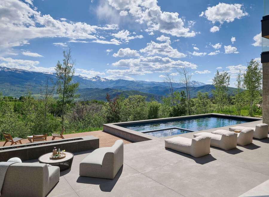 Experience luxury outdoor living with this stunning property featuring a modern infinity pool and a sleek fire pit area, perfect for entertaining.