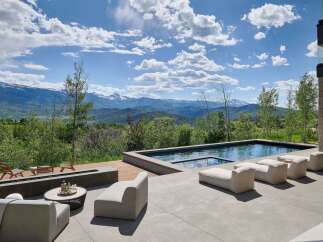 Experience luxury outdoor living with this stunning property featuring a modern infinity pool and a sleek fire pit area, perfect for entertaining.
