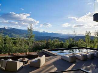 Experience luxury outdoor living with this stunning property featuring a modern infinity pool and a sleek fire pit area, perfect for entertaining.
