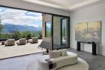 Experience breathtaking mountain views from this luxurious modern living space, featuring expansive sliding glass doors that seamlessly connect indoor and outdoor living.