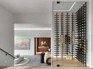 Experience luxury living with this stunning modern home featuring a state-of-the-art glass-enclosed wine cellar, perfect for the discerning collector.