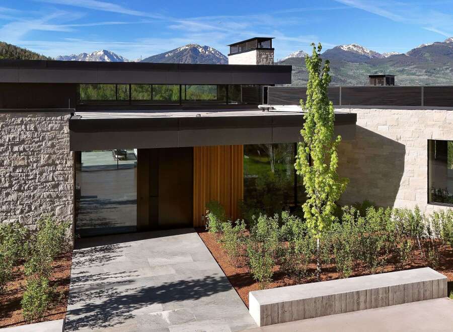 Experience modern luxury with this stunning architectural masterpiece, featuring a striking stone facade and expansive glass windows that frame breathtaking mountain views.