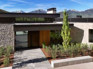 Experience modern luxury with this stunning architectural masterpiece, featuring a striking stone facade and expansive glass windows that frame breathtaking mountain views.