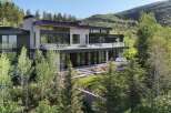 Experience modern luxury in this stunning mountain home, featuring expansive glass walls and sleek architectural lines that blend seamlessly with the natural landscape.