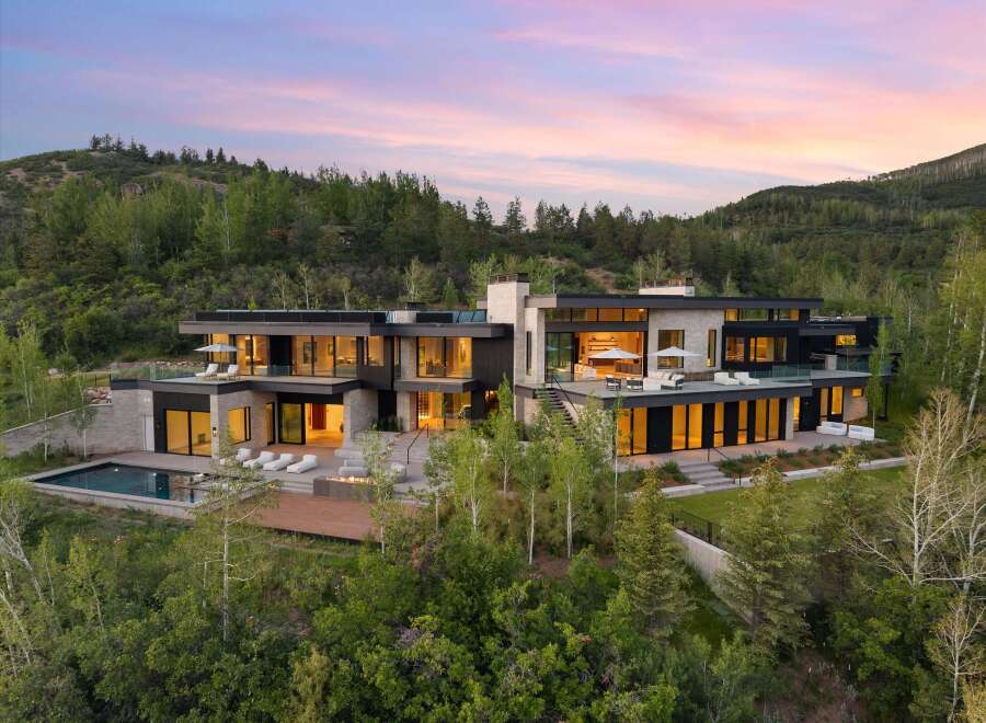 Experience luxury mountain living in this stunning modern estate, nestled amidst a serene forest landscape.