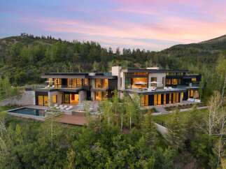 Experience luxury mountain living in this stunning modern estate, nestled amidst a serene forest landscape.