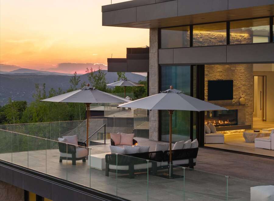 Experience luxury outdoor living with this stunning patio featuring comfortable seating, a modern fire pit, and expansive mountain views.