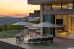 Experience luxury outdoor living with this stunning patio featuring comfortable seating, a modern fire pit, and expansive mountain views.