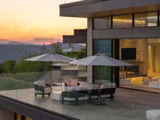 Experience luxury outdoor living with this stunning patio featuring comfortable seating, a modern fire pit, and expansive mountain views.