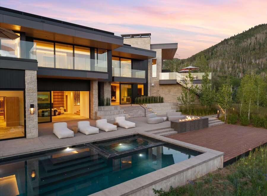 Experience luxury mountain living in this stunning modern estate, featuring a sleek infinity pool and spa overlooking a serene landscape.