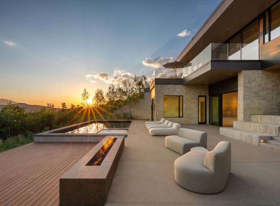 Experience luxury living with this stunning modern home featuring a sleek infinity pool and a captivating fire pit, perfect for evening relaxation.