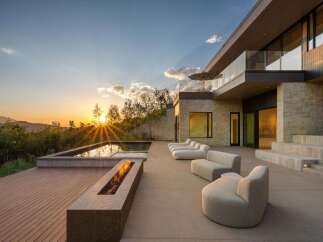 Experience luxury living with this stunning modern home featuring a sleek infinity pool and a captivating fire pit, perfect for evening relaxation.