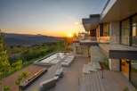 Experience luxury living with this stunning modern home featuring a sleek infinity pool and a linear gas fireplace, perfect for enjoying breathtaking sunset views over the mountains.