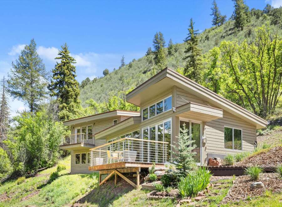 Nestled amidst a lush hillside, this contemporary home offers stunning natural views and a seamless indoor-outdoor living experience.