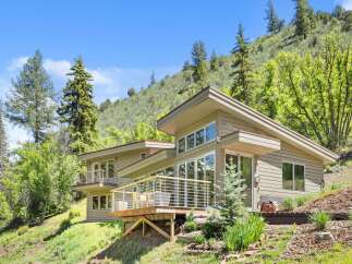 Nestled amidst a lush hillside, this contemporary home offers stunning natural views and a seamless indoor-outdoor living experience.