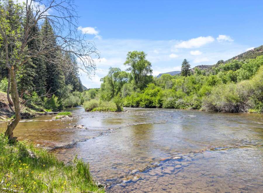 Experience serene living with this stunning property featuring a crystal-clear river flowing through lush greenery.