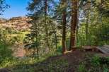 Escape to this serene mountain retreat, offering breathtaking views of a winding river and rugged red rock formations.