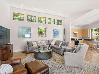 This spacious living room boasts a large sectional sofa, comfortable leather armchairs, and a stylish coffee table, perfect for entertaining.