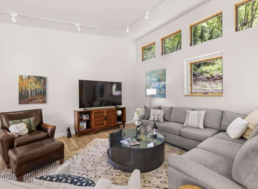 Experience modern living in this spacious living room, featuring a large sectional sofa perfect for gatherings and a stylish media console.