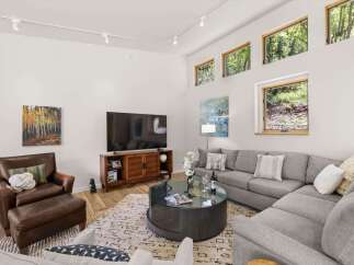 Experience modern living in this spacious living room, featuring a large sectional sofa perfect for gatherings and a stylish media console.