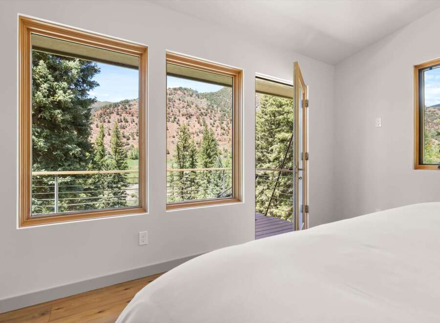 Experience breathtaking mountain views from this stunning bedroom, featuring large windows that frame the picturesque landscape.