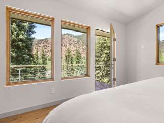 Experience breathtaking mountain views from this stunning bedroom, featuring large windows that frame the picturesque landscape.