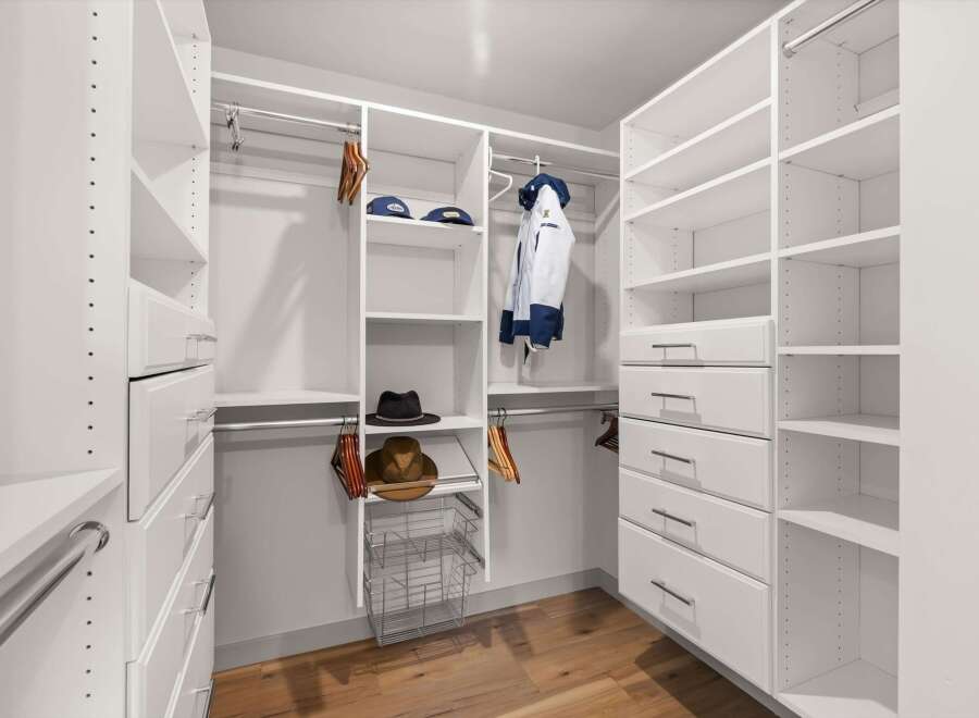 Step into this spacious walk-in closet, meticulously designed for optimal organization and style.