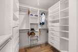 Step into this spacious walk-in closet, meticulously designed for optimal organization and style.