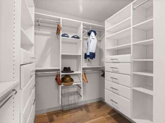 Step into this spacious walk-in closet, meticulously designed for optimal organization and style.