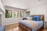 Experience breathtaking mountain views from this serene bedroom, featuring three large windows that flood the space with natural light.