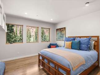 Experience breathtaking mountain views from this serene bedroom, featuring three large windows that flood the space with natural light.