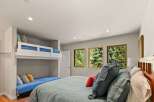 This bedroom offers a unique sleeping arrangement with a built-in bunk bed and a lower daybed, perfect for families or guests.