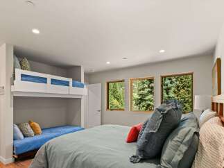 This bedroom offers a unique sleeping arrangement with a built-in bunk bed and a lower daybed, perfect for families or guests.