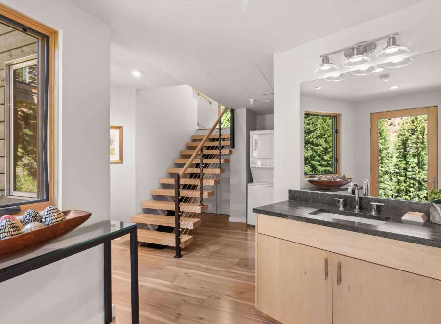 Experience modern living with this stunning home featuring a floating staircase and a sleek vanity area.
