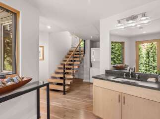 Experience modern living with this stunning home featuring a floating staircase and a sleek vanity area.