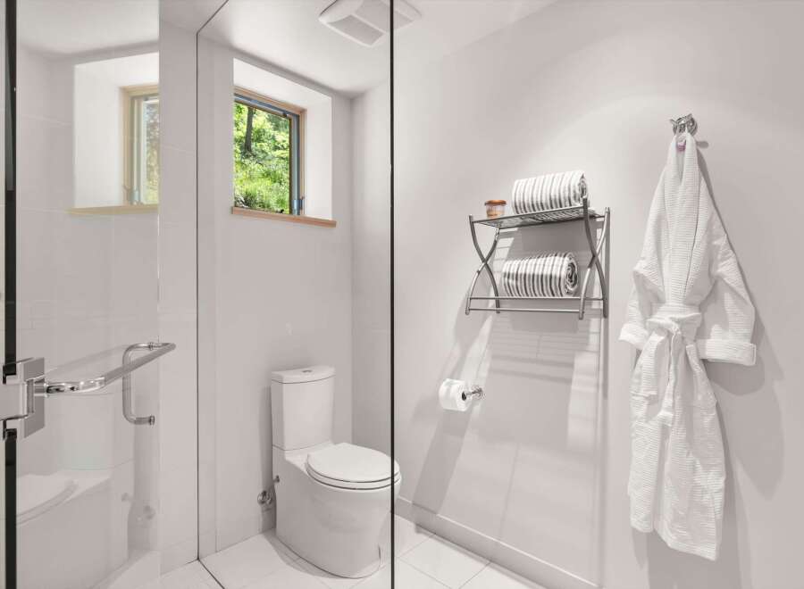 Experience modern comfort in this pristine bathroom, featuring a sleek glass-enclosed shower and a contemporary toilet.