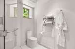 Experience modern comfort in this pristine bathroom, featuring a sleek glass-enclosed shower and a contemporary toilet.
